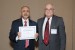 Dr. Nagib Callaos, General Chair, giving Prof. Ata Khan the best paper award certificate of the session "Information Systems, Technologies and Applications I." The title of the awarded paper is "Cognitive Connected Vehicle Information System Design Requirement for Safety: Role of Bayesian Artificial Intelligence."